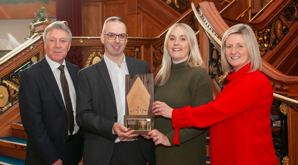 4 people standing holding up a BITC Environmental Benchmarking platinum award